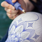 Rhian Malin decorating a mandala bottle in her workshop 2019